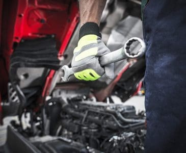 Technician hand in a glove holding a wrench