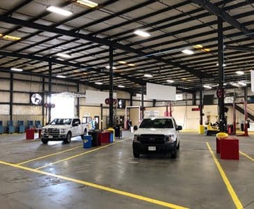 Vector maintenance garage with two white trucks parked