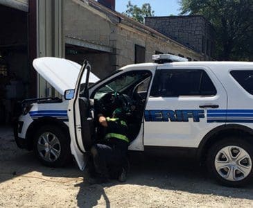 Vector technician doing maintenance on a sheriff car