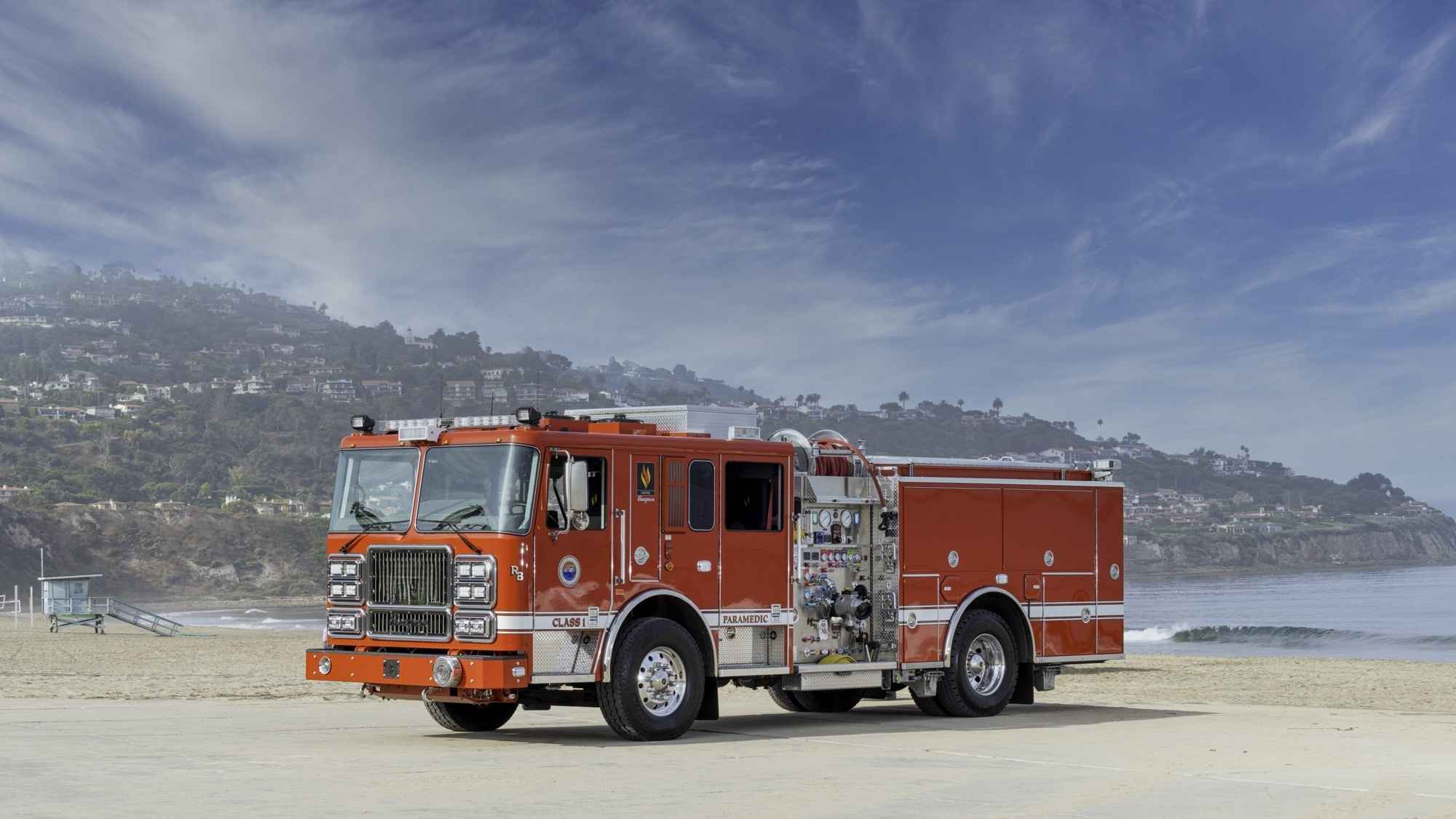 Fire truck parked with the beach and ocean behind it